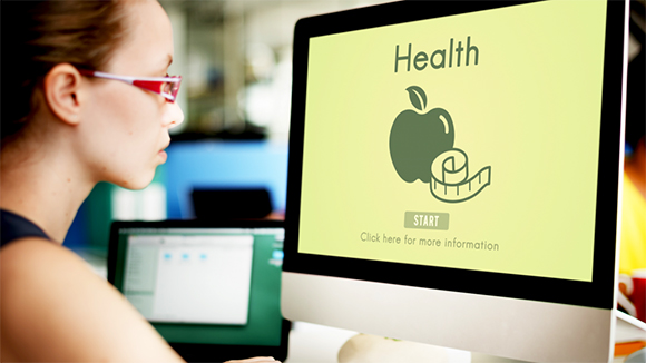 young woman looking up health programs on a computer