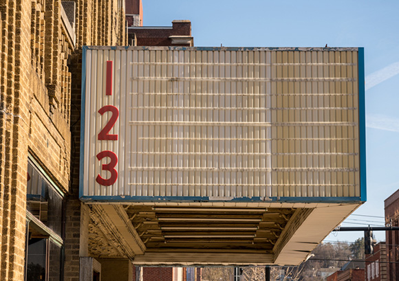 side view of an empty, rundown cinema billboard