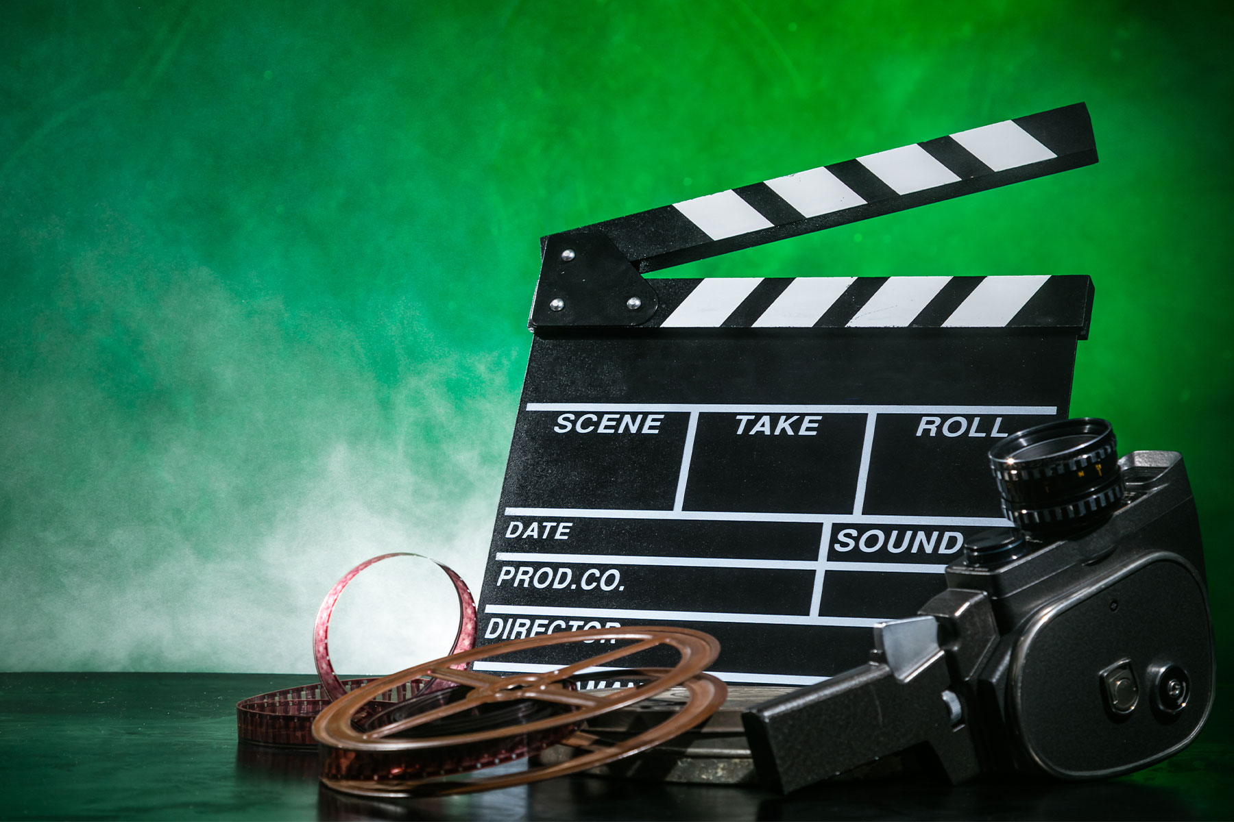 Retro film production accessories on green smoky background