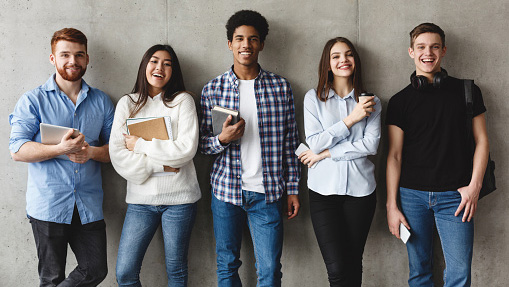 group of diverse students lined up along wall for a photo