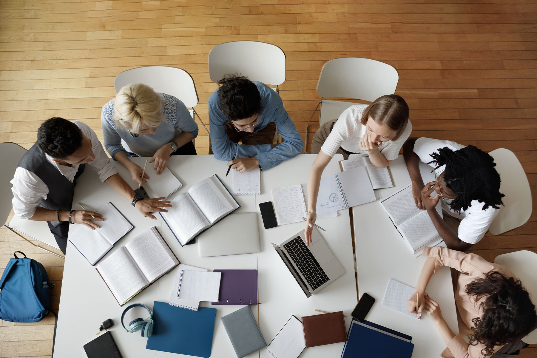 overhead view of group of students working around a large desk