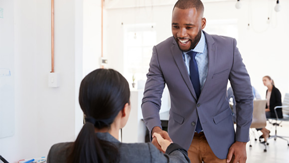 young professional black man shakes hand with a professor or interviewer