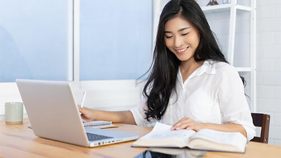 young woman happily working on laptop