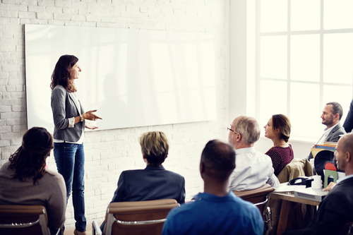 female presenter in front of peers