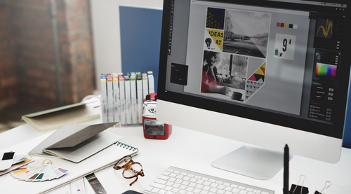 close-up of a designers desk with color wheels, computer, and other design tools