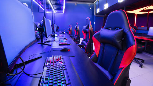 esports set-up with a row of gaming computers and empty gaming chairs