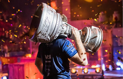 esports player holding a large trophy over his shoulder