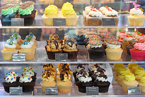 rows of cupcakes in a bakery display case