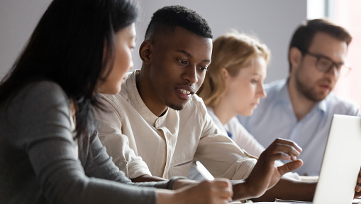 group of professionals working together on laptops