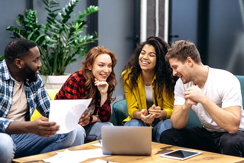 group of friends gathered around laptop