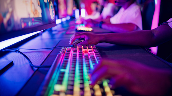 close up of hands on a lit up gaming keyboard