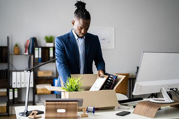 young man packing up modern desk