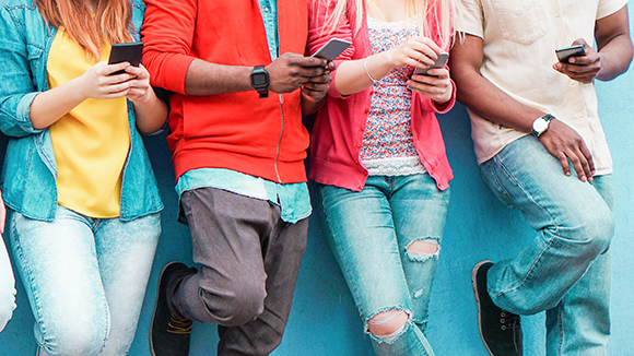 line of young people one their cellphones