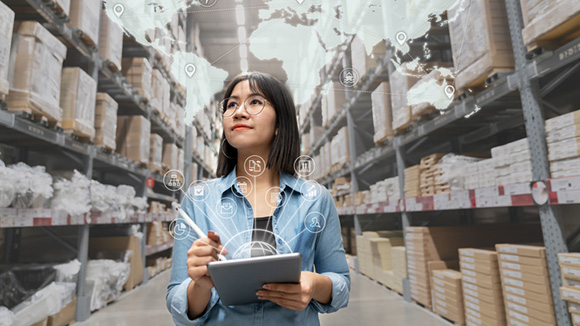 young attractive asian entrepreneur woman looking at inventory in warehouse using smart tablet