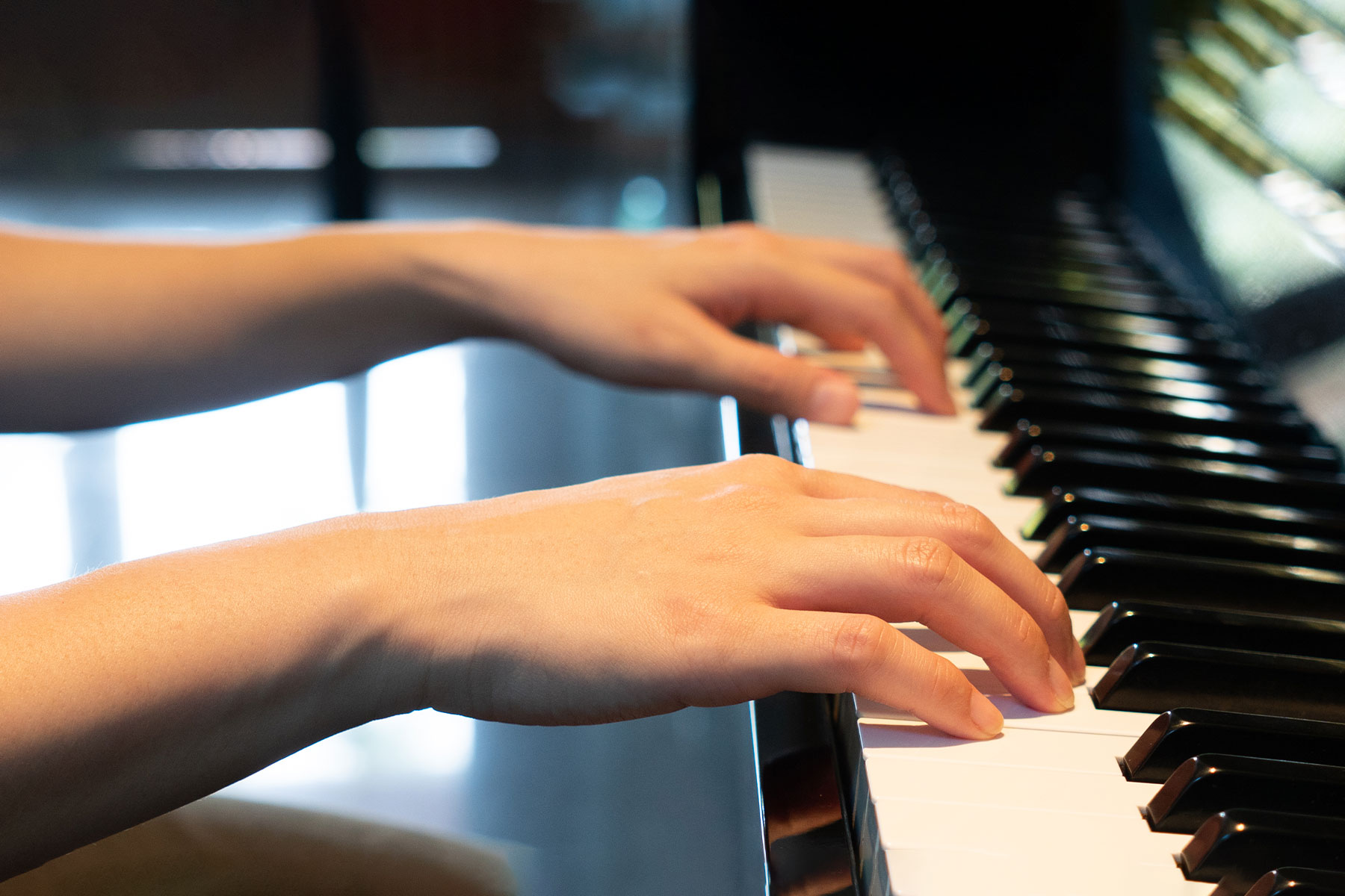 close up of hands playing a piano