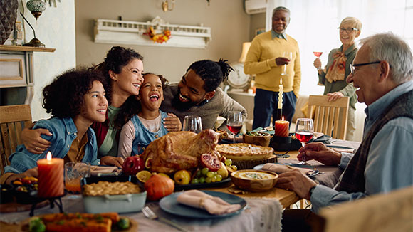 diverse group of family and friends celebrating thanksgiving dinner