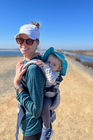 Coastline College Instructor Stacey Smith hiking with her family's newest addition hitching a ride.