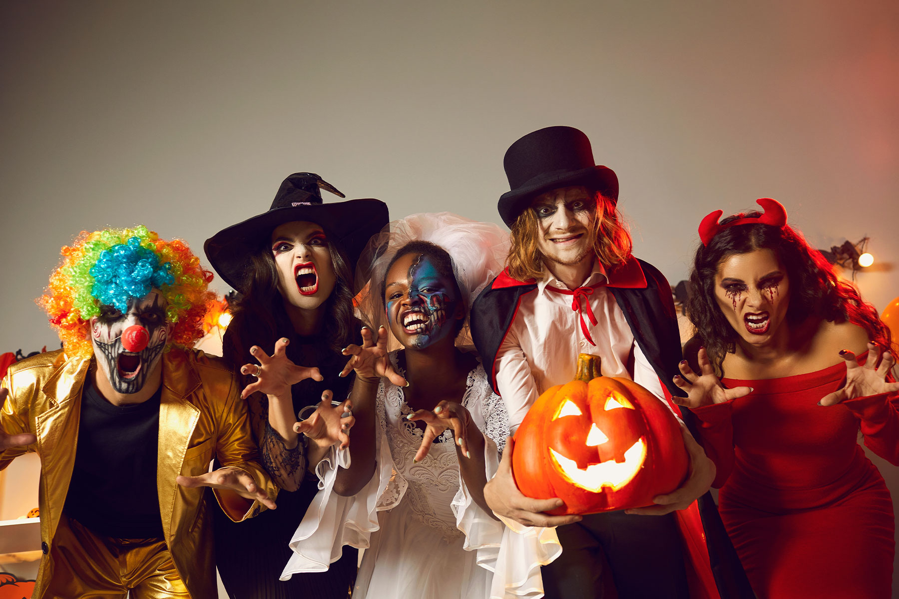 Group of young people dressed up as spooky characters having fun at Halloween costume party.