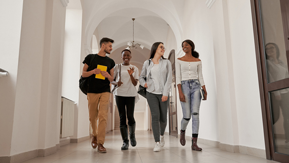 view of 4 college student walking down a corridor