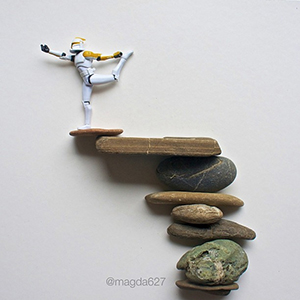 a clone trooper action figure doing yoga on balanced rocks