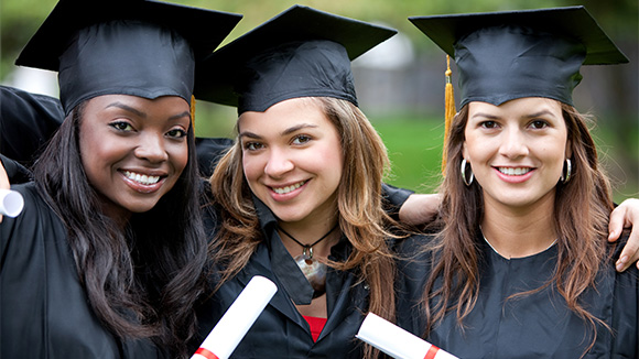three young female graduates pose for a photo