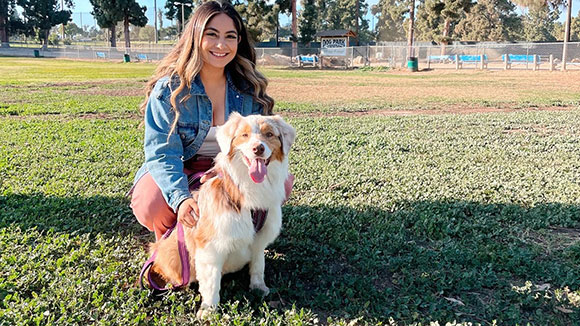 Vianca Cortes and her dog pose at a dog park