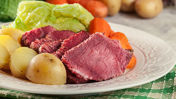 close up of a plate of corned beef, cabbage, potatoes, and carrots