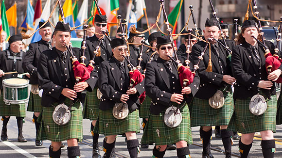 a group of bagpipe players marching in a st. patrick's day parade