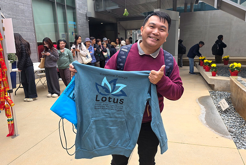 student holding lotus sweater