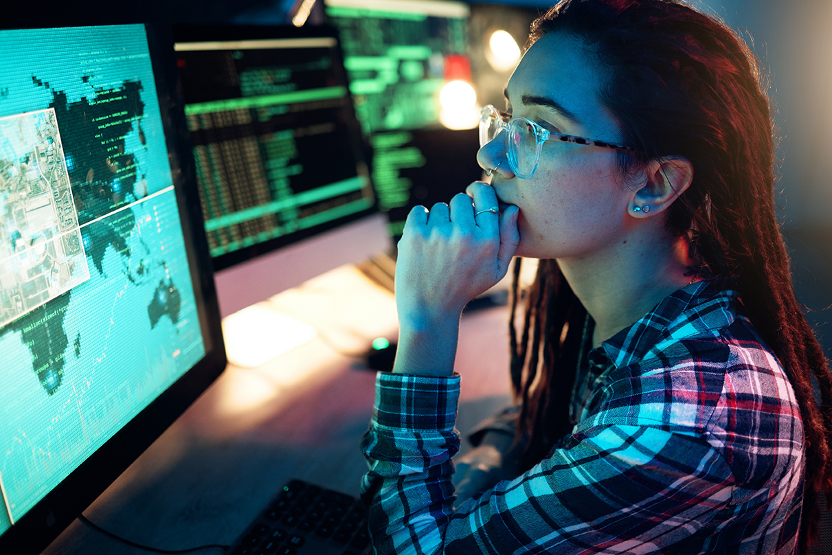 female cyber operations specialist studying monitors