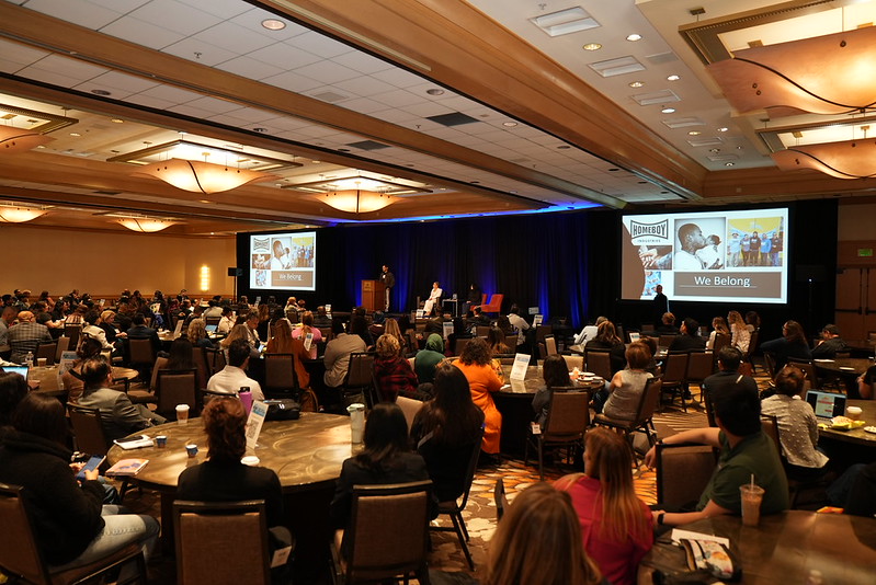 conference hall, with a panel of incarcerated students in the background